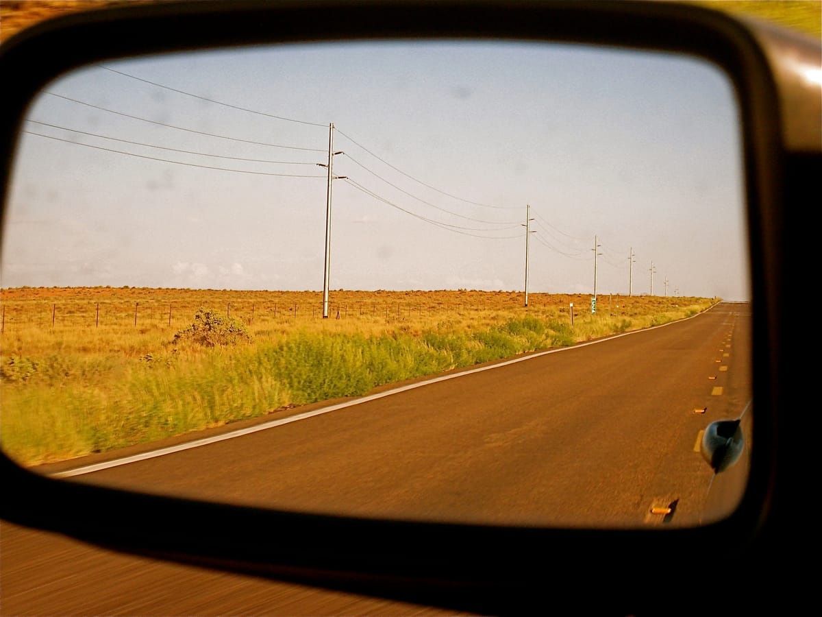 Ruta vista desde el espejo retrovisor de un auto
